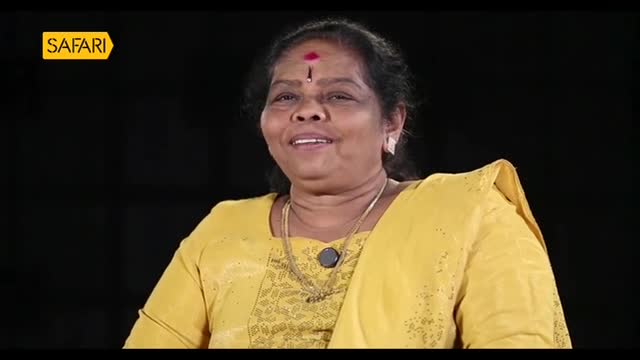 A woman in a yellow sari smiles, a red bindi on her forehead. The Safari TV logo is visible in the corner.
