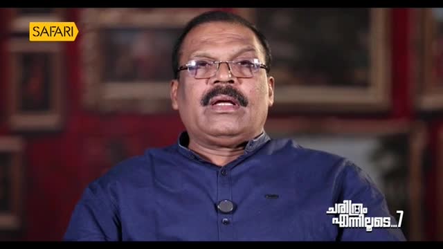 A man in glasses and a blue shirt is speaking, his mouth open as he talks. The Safari TV logo is visible in the corner.
