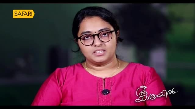 A woman with glasses speaks directly to the camera, her bright pink top contrasting with the dark background. A yellow "Safari" logo sits in the upper left corner, and Malayalam script appears on the right. A woman with glasses speaks directly to the camera, her bright pink top contrasting with the dark background. A yellow "Safari" logo sits in the upper left corner, and Malayalam script appears on the right.