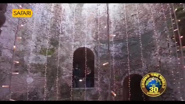 Strings of lights hang from a rough brick wall, illuminating two figures in an arched doorway. The "Safari" logo is visible in the upper left corner. Strings of lights hang from a rough brick wall, illuminating two figures in an arched doorway. The "Safari" logo is visible in the upper left corner.