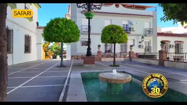 A small fountain sprays water in a courtyard. The Safari TV logo is visible in the upper left corner.