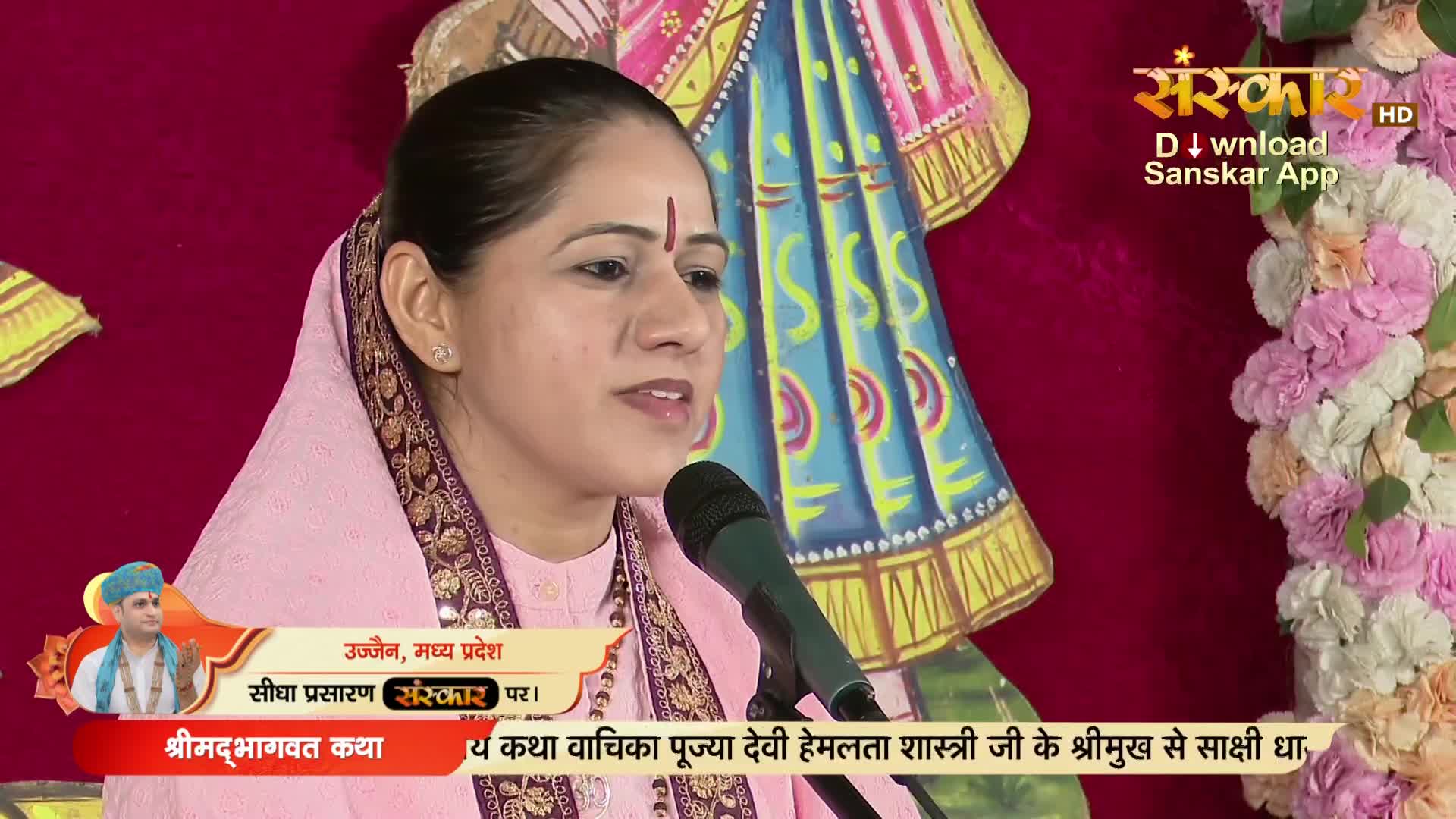 A woman in a pink headscarf speaks into a microphone, her face illuminated. The broadcast of a religious discourse is underway on Sanskar TV, with graphics identifying the location as Ujjain, Madhya Pradesh.
