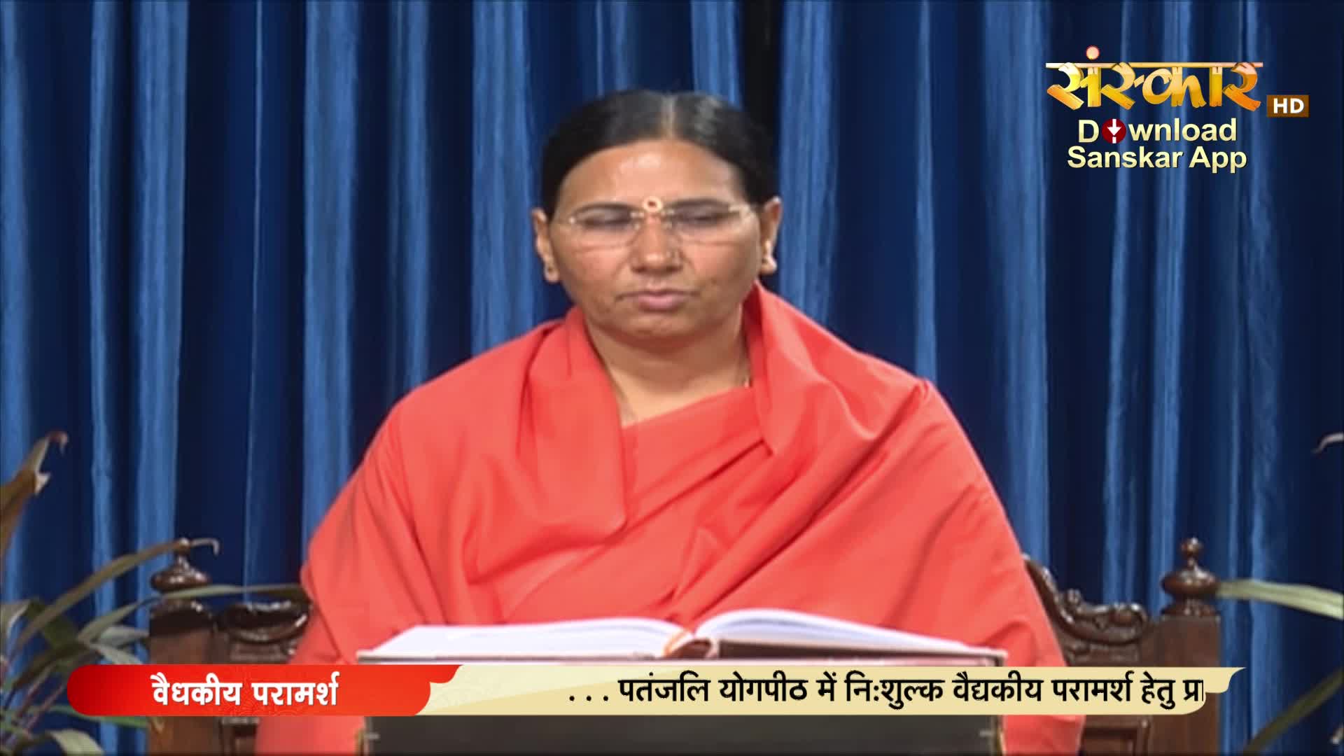 A woman in an orange robe sits before an open book, eyes closed, as if in meditation. The Sanskar TV logo and Hindi text at the bottom suggest a program about health advice.
