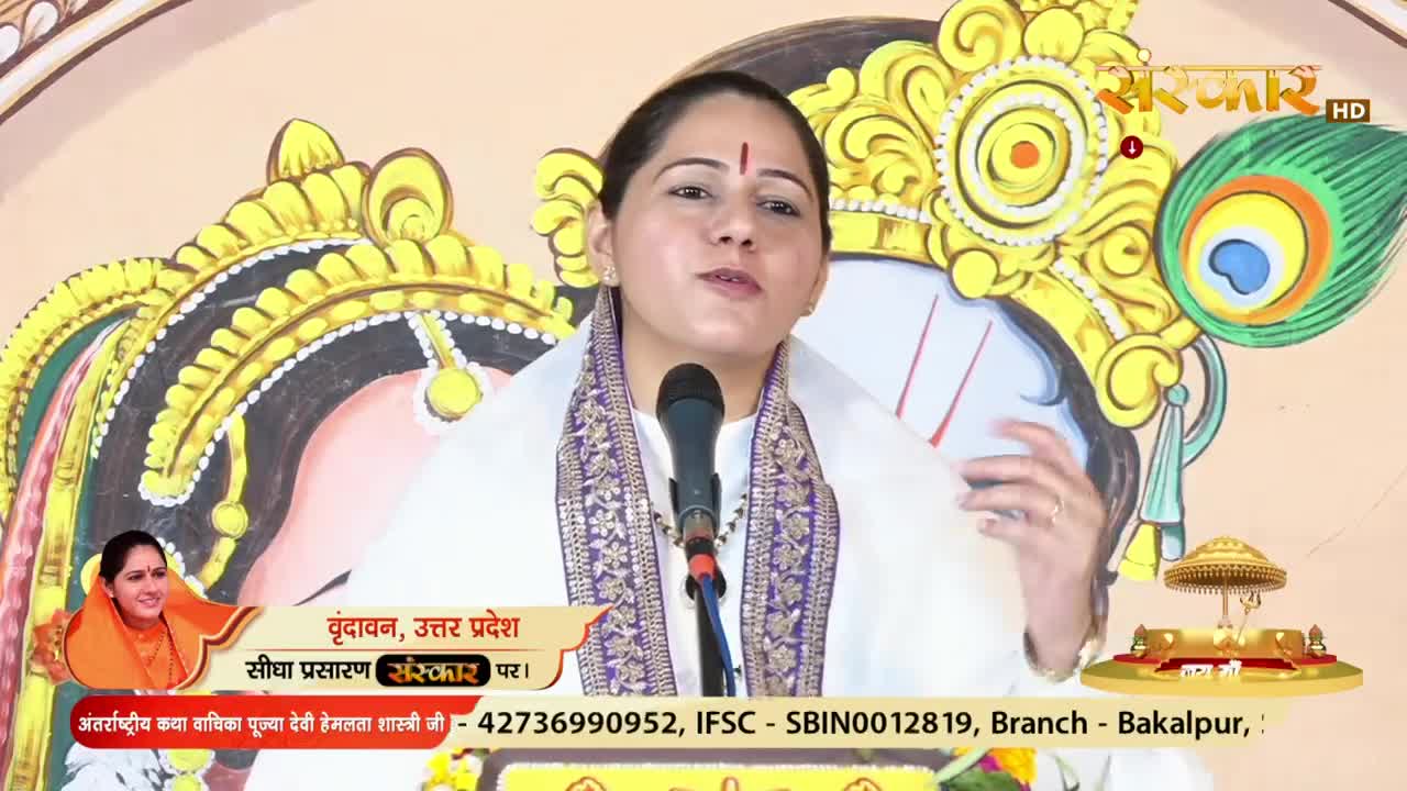 A woman, wearing a white shawl and a red bindi, speaks into a microphone on a set for Sanskar TV. Below her, text identifies the location as Vrindavan, Uttar Pradesh, India.
