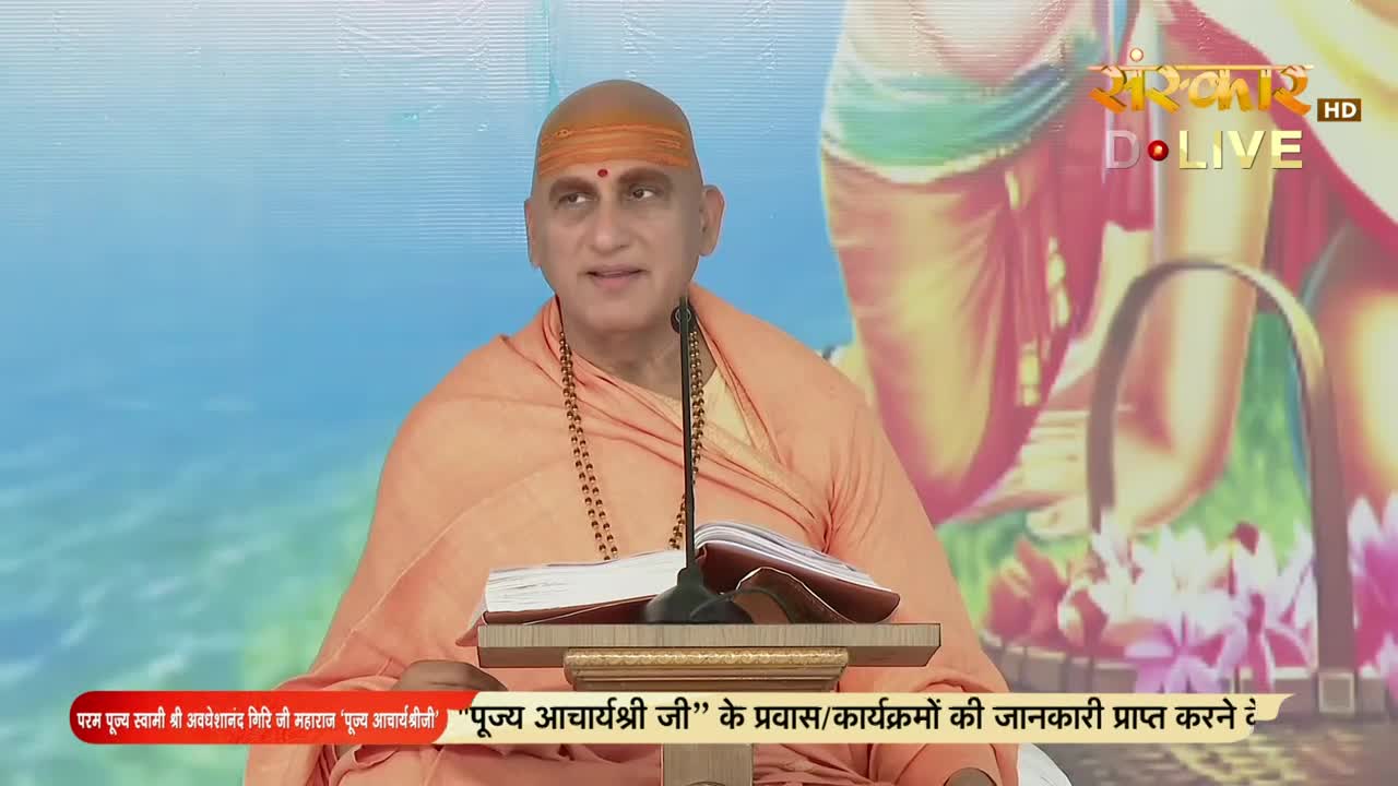 A man in orange robes speaks, his gaze directed towards the camera, a microphone close by. The Sanskar TV logo is visible in the corner, and a banner at the bottom mentions "Pujya Acharyashree Ji."
