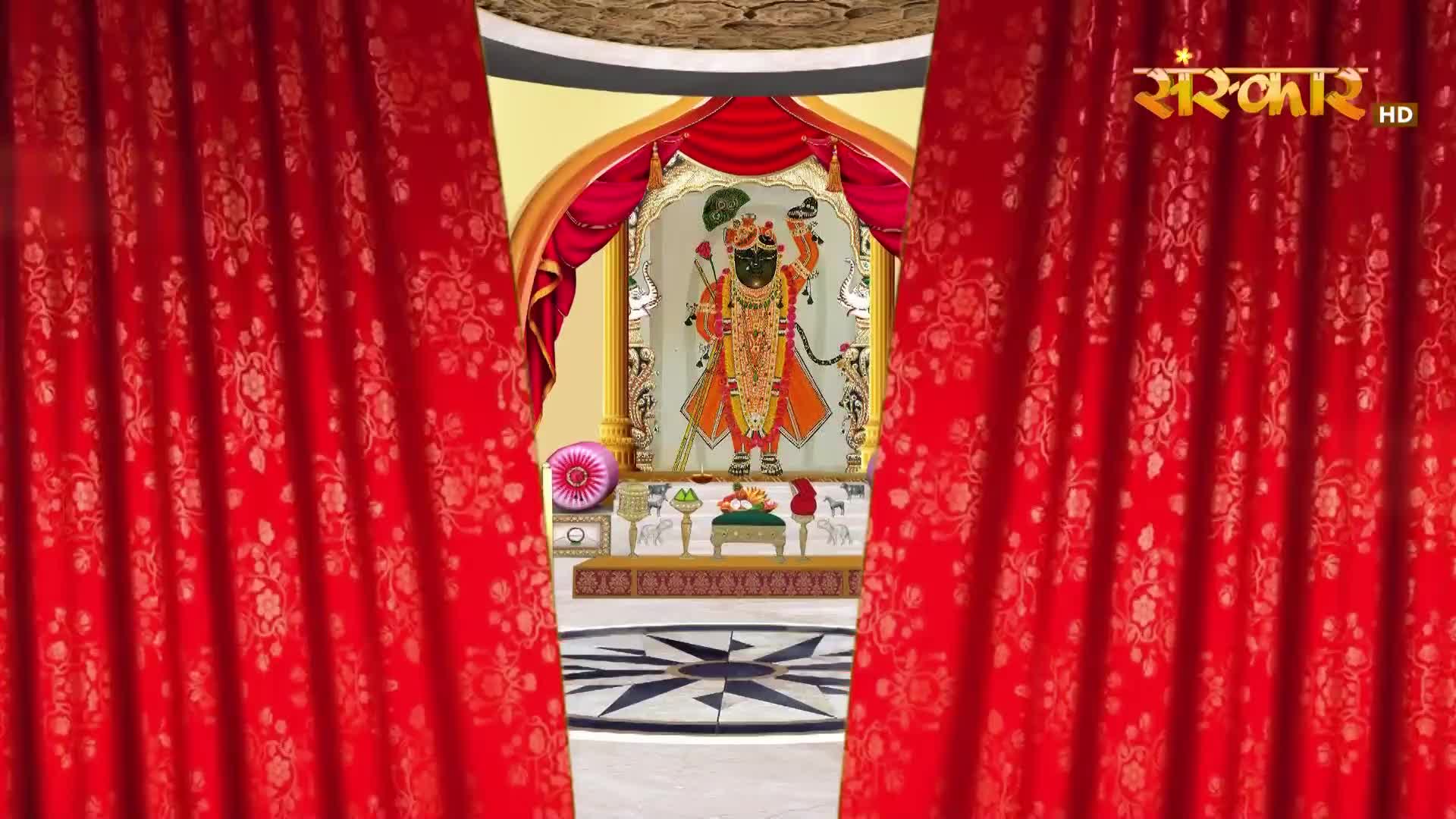 The heavy red curtains part to reveal a shrine. A painted deity stands in an ornate frame, adorned in vibrant clothing.