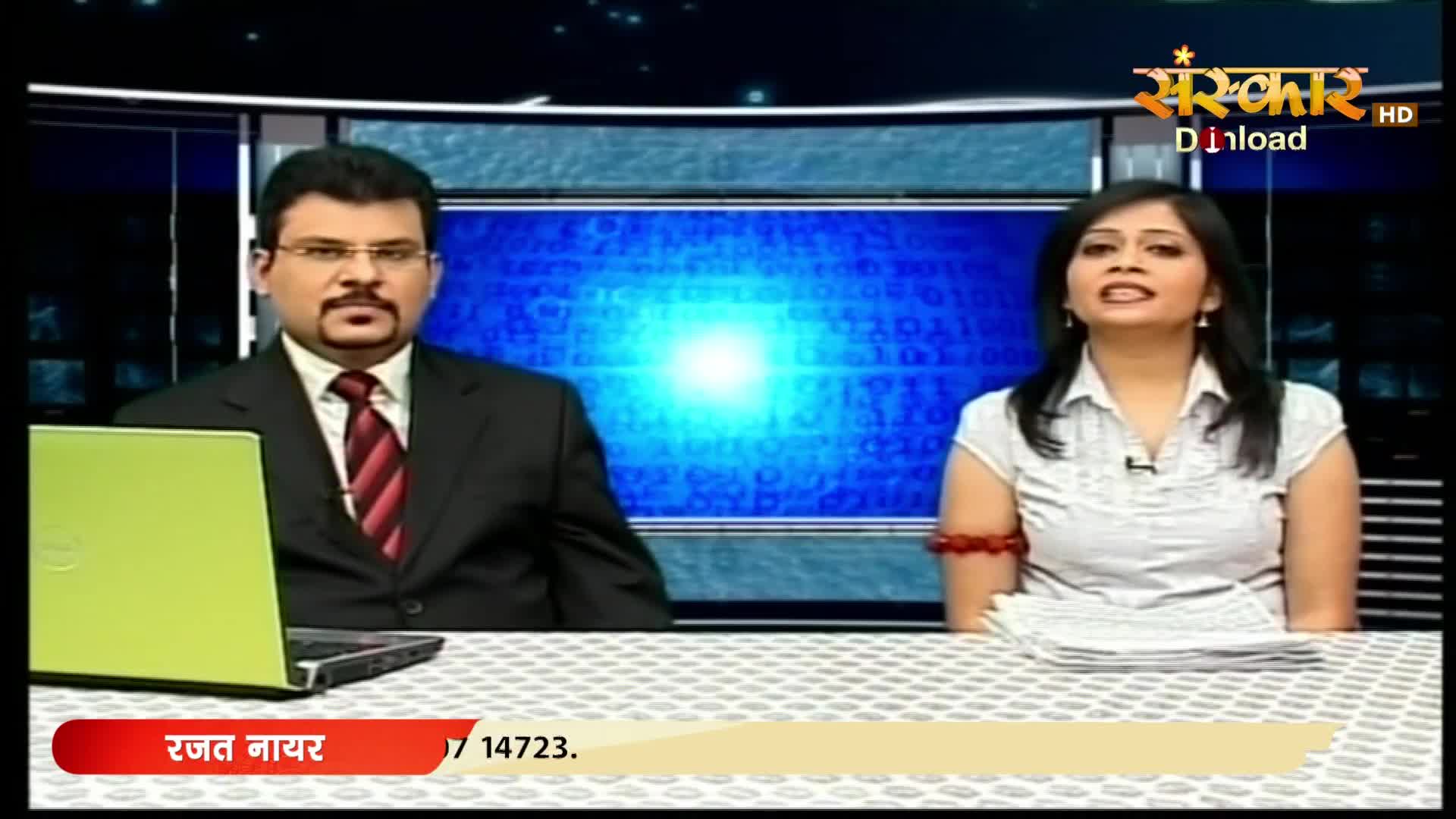 A man in a suit and tie sits beside a bright green laptop. A woman in a white shirt speaks animatedly to his right. The Sanskar HD logo appears in the upper right corner.