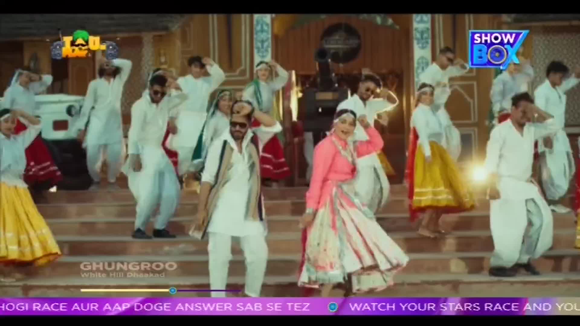 A group of people in traditional Indian clothing are dancing on a set of stairs. The scene is part of a music video, as indicated by the "ShowBox" logo and the song title at the bottom.
