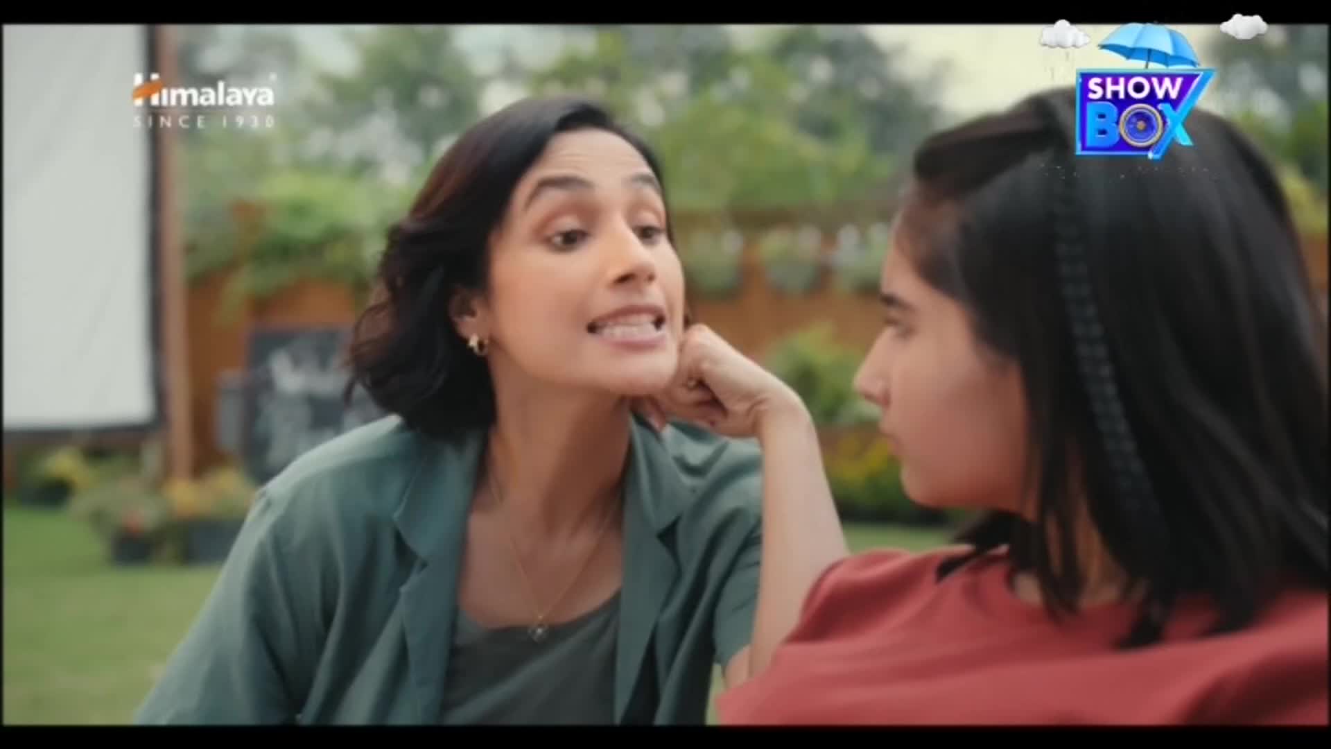 The woman on the left gestures emphatically, her mouth open as she speaks.  Her companion listens, resting her hand on her cheek, the ShowBox logo floating above them.
