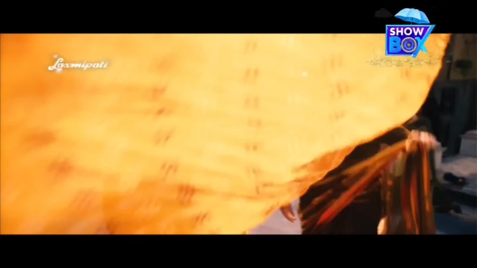 A large, golden fabric billows across the frame, pulled taut by unseen hands. The scene is likely from a ShowBox production, judging by the logo in the corner.
