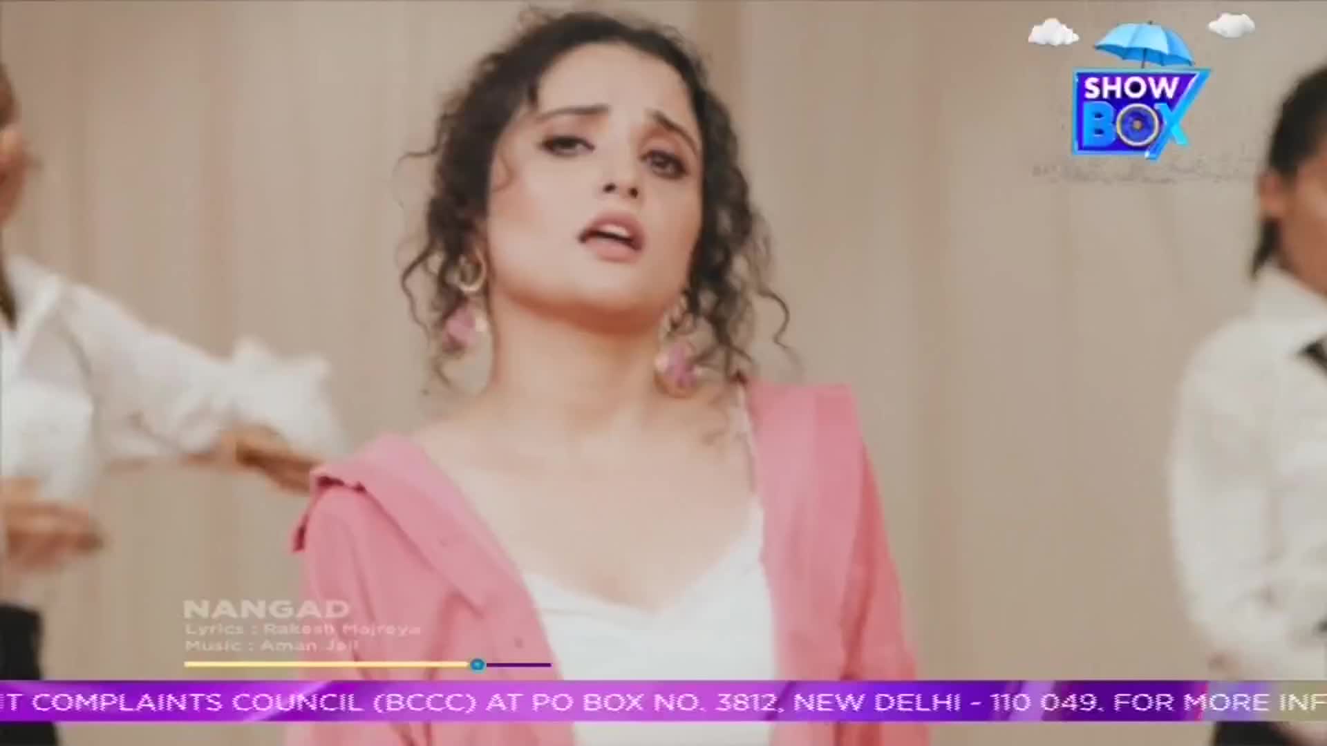 A woman in a pink jacket sings with her mouth open, looking upwards. The ShowBox logo is visible in the top right corner, and the lyrics are displayed at the bottom.
