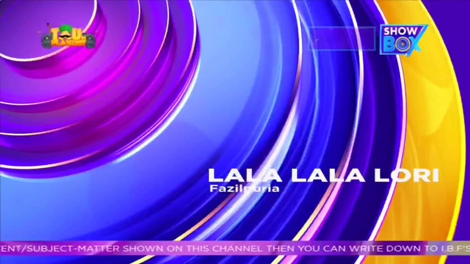 The ShowBox logo sits in the top right corner, while the words "LALA LALA LORI" are displayed in the center. Swirling blue and purple shapes create a vibrant background.

