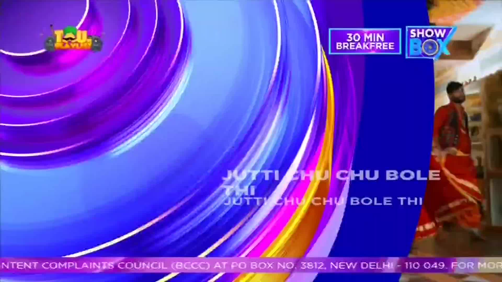 A man in red clothing walks past a wall, while a swirling, colorful graphic fills the left side of the screen. The words "Jutti Chu Chu Bole Thi" are written on the screen, along with the ShowBox logo.
