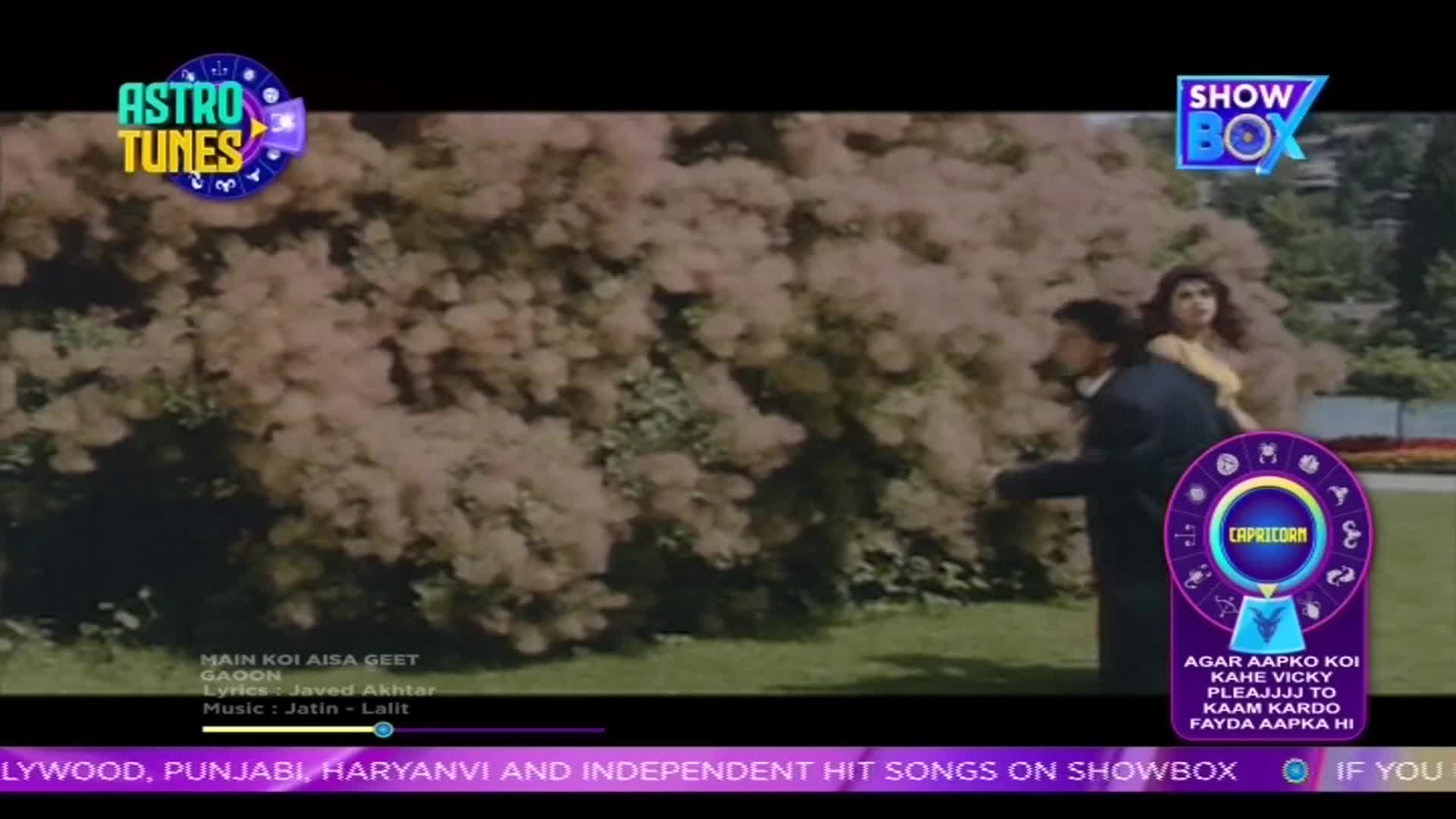 A man in a dark suit turns his back to the camera, his arm extended towards a woman in a yellow top. A horoscope graphic hovers near them, with the ShowBox logo visible above.