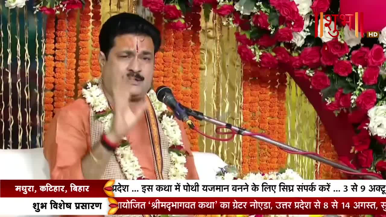 A man in an orange robe gestures emphatically, speaking into a microphone. The scene is broadcast on Shubh TV, with text scrolling across the bottom about an event in Uttar Pradesh.

