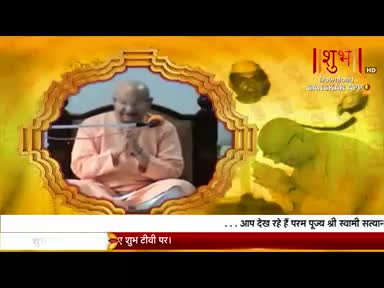 A man in peach robes sits in a framed image, hands clasped, as if in prayer, on Shubh TV. The lower third of the screen displays text in Hindi.
