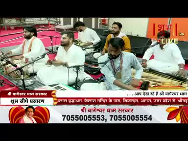 Musicians in white kurtas and tunics are seated on a stage, playing instruments like a tabla and what looks like a harmonium. The broadcast is live on Shubh TV from India.
