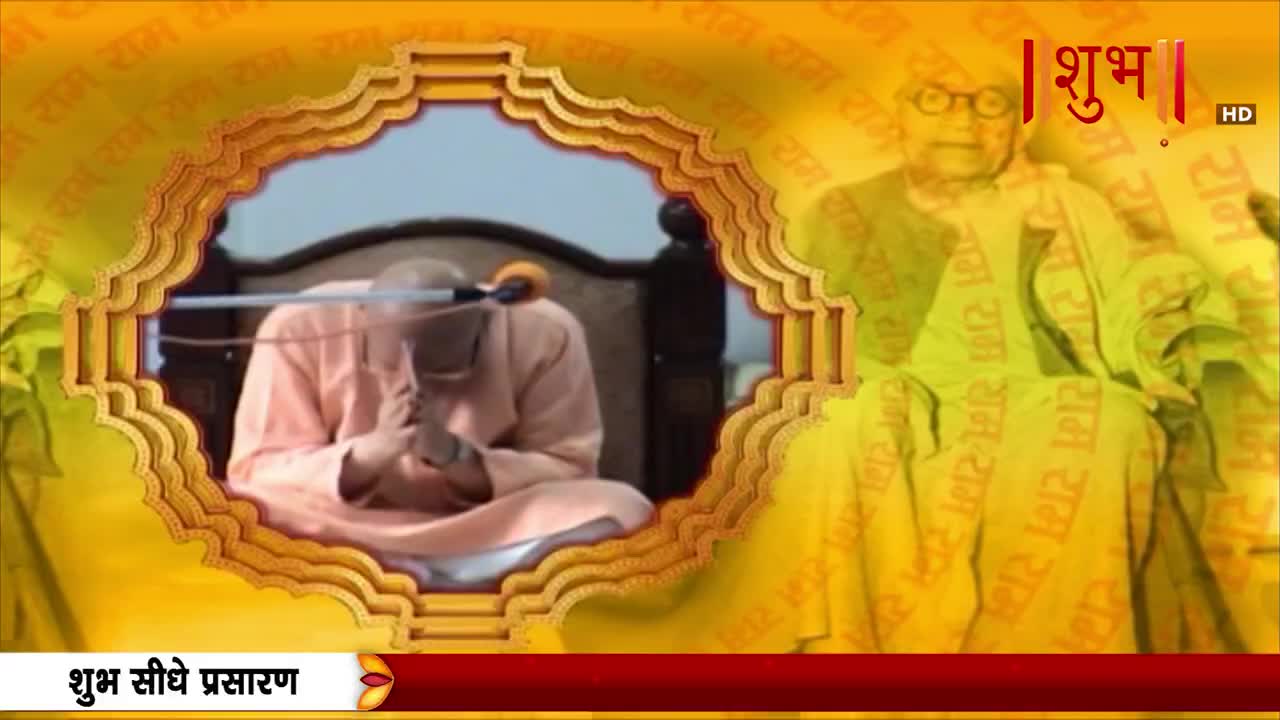 A man in a peach robe sits with hands clasped, framed by an ornate gold border, likely on Shubh TV, an Indian channel. The background is a golden hue with repeated text, and a graphic of a man in glasses is visible.
