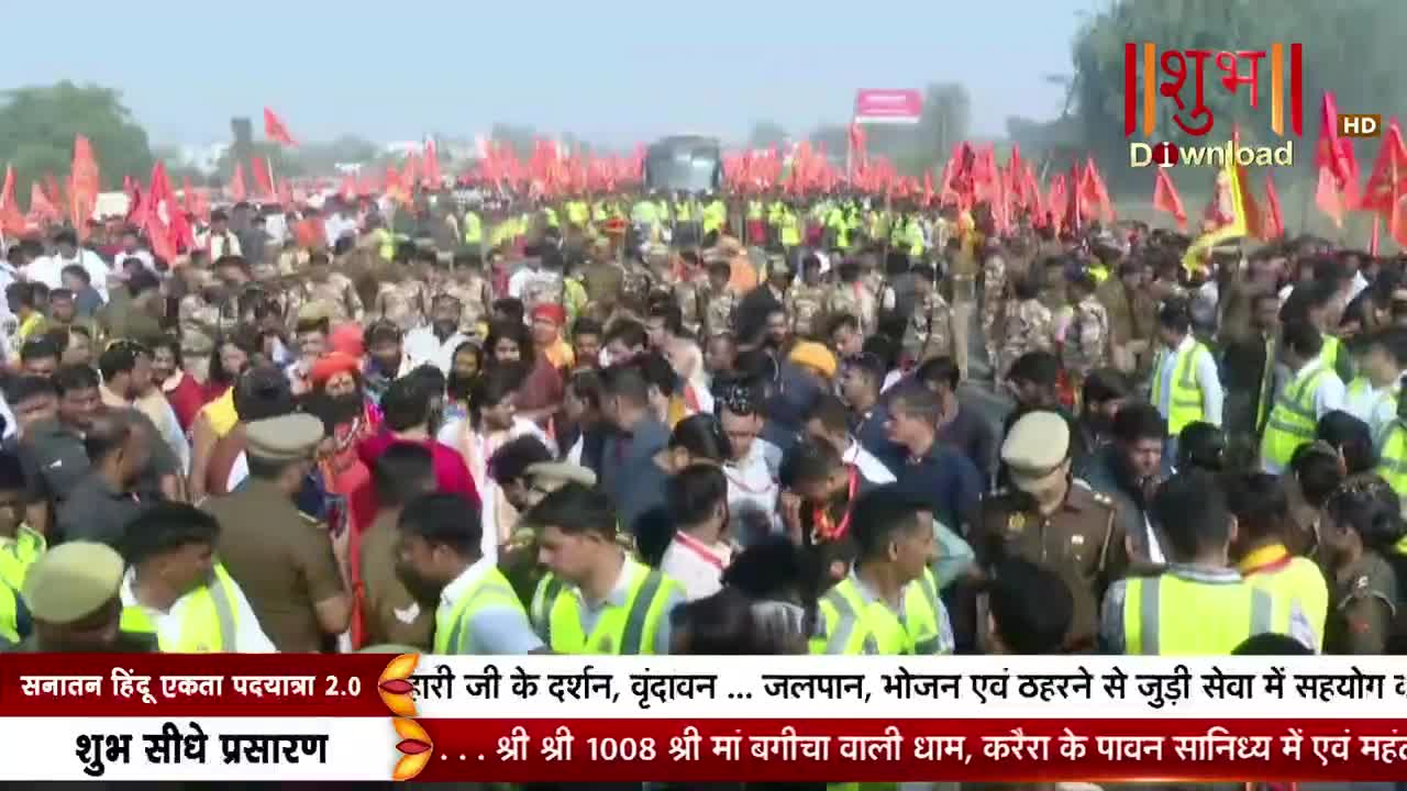 A massive crowd is moving forward, many holding red flags, with security personnel in green vests and uniforms interspersed throughout. The scene is being broadcast live on Shubh TV, as the text at the bottom indicates.
