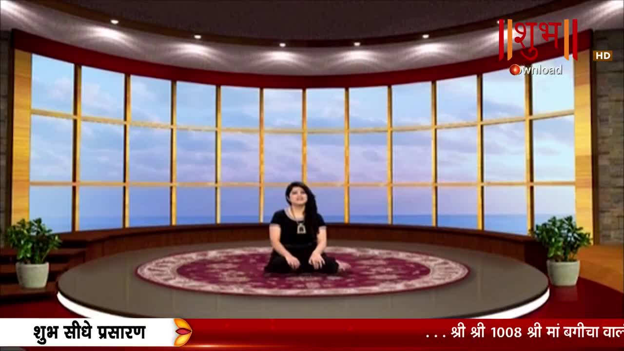 A woman sits cross-legged on a patterned rug, framed by a large window overlooking a painted landscape. The Shubh TV logo is visible, and the broadcast is labeled "Shubh Sidhe Prasaran."
