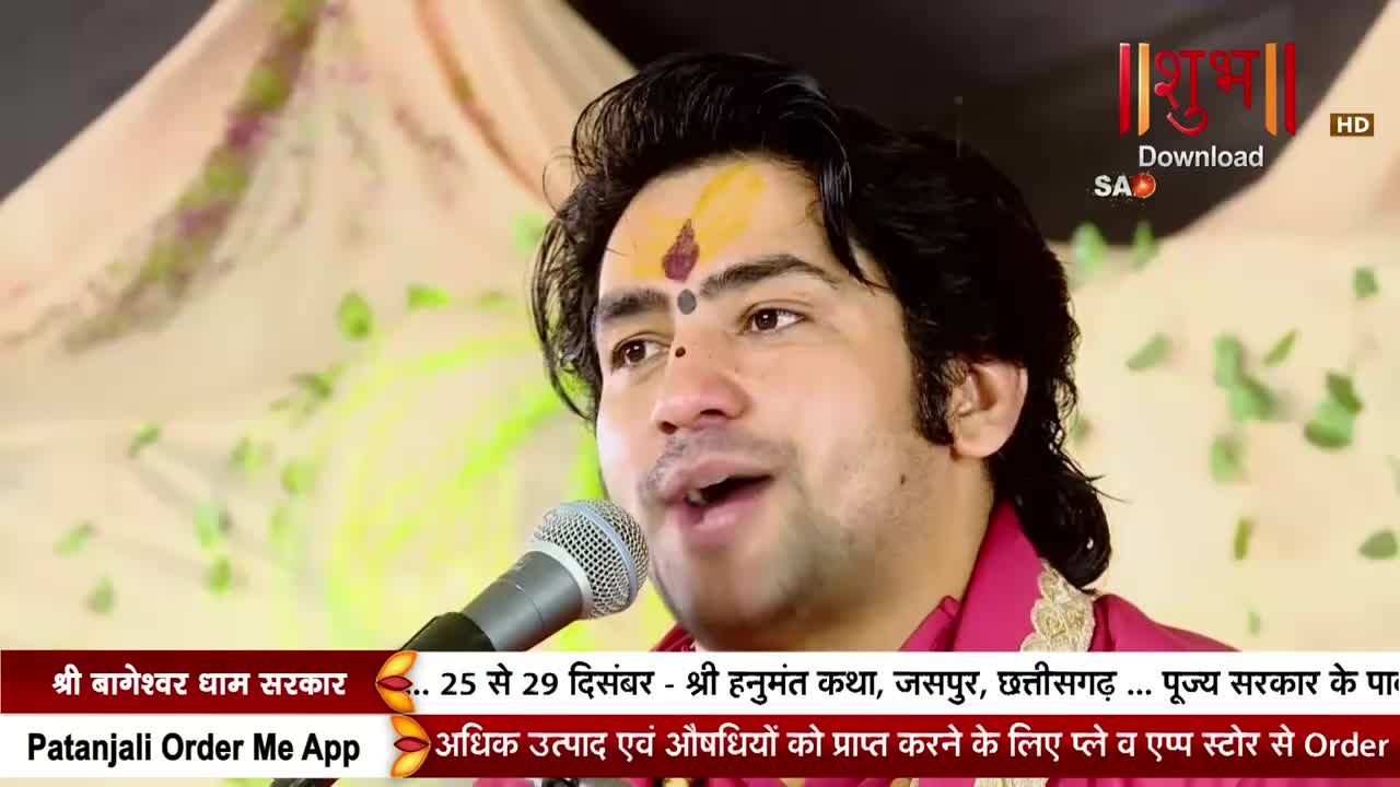 A man with a painted forehead speaks into a microphone, his face lit by the camera. The Shubh TV logo and Hindi text appear in the corner and bottom of the screen.
