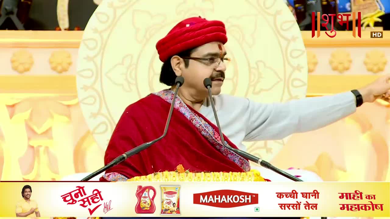 A man in a red turban and shawl gestures emphatically, speaking into two microphones. The Shubh TV logo and Hindi text are visible at the top of the screen.
A man in a red turban and shawl gestures emphatically, speaking into two microphones. The Shubh TV logo and Hindi text are visible at the top of the screen.