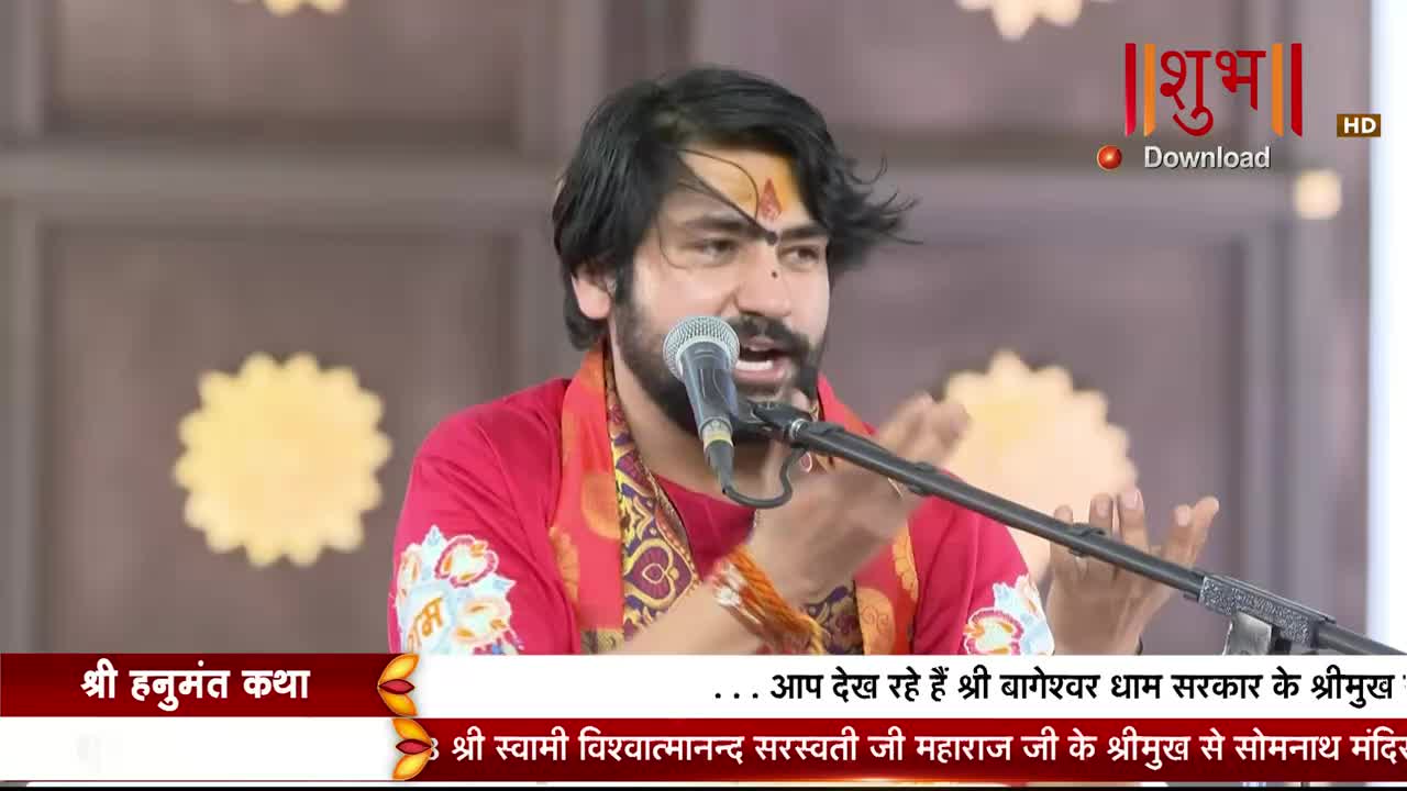 A man in a red shirt gestures with his hands while speaking into a microphone. The Shubh TV logo and Hindi text are visible in the corner of the screen.
A man in a red shirt gestures with his hands while speaking into a microphone. The Shubh TV logo and Hindi text are visible in the corner of the screen.