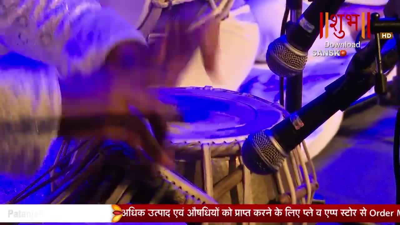 Fingers dance across the tabla, a blur of motion under the stage lights. Microphones stand ready, capturing every beat of the performance.