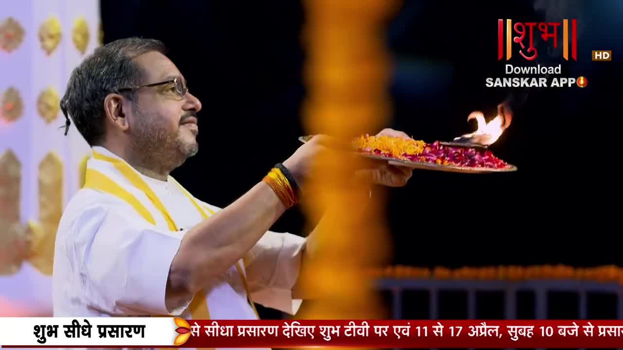 A man in a white kurta holds a plate with flowers and a flame, his arm raised. The Shubh TV logo appears in the upper right corner. A man in a white kurta holds a plate with flowers and a flame, his arm raised. The Shubh TV logo appears in the upper right corner.