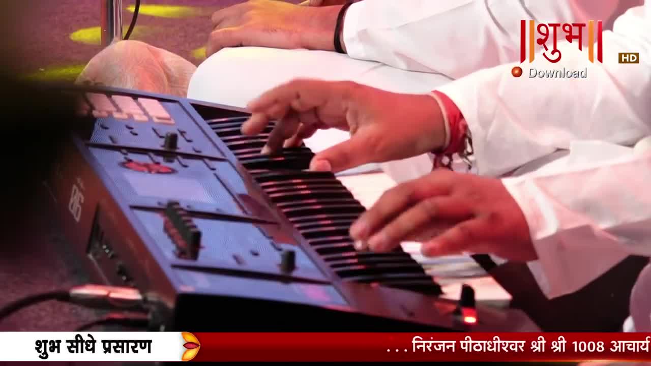 Fingers dance across the keyboard, their movements precise and practiced. The Shubh TV logo is visible, a familiar sight during live broadcasts. Fingers dance across the keyboard, their movements precise and practiced. The Shubh TV logo is visible, a familiar sight during live broadcasts.