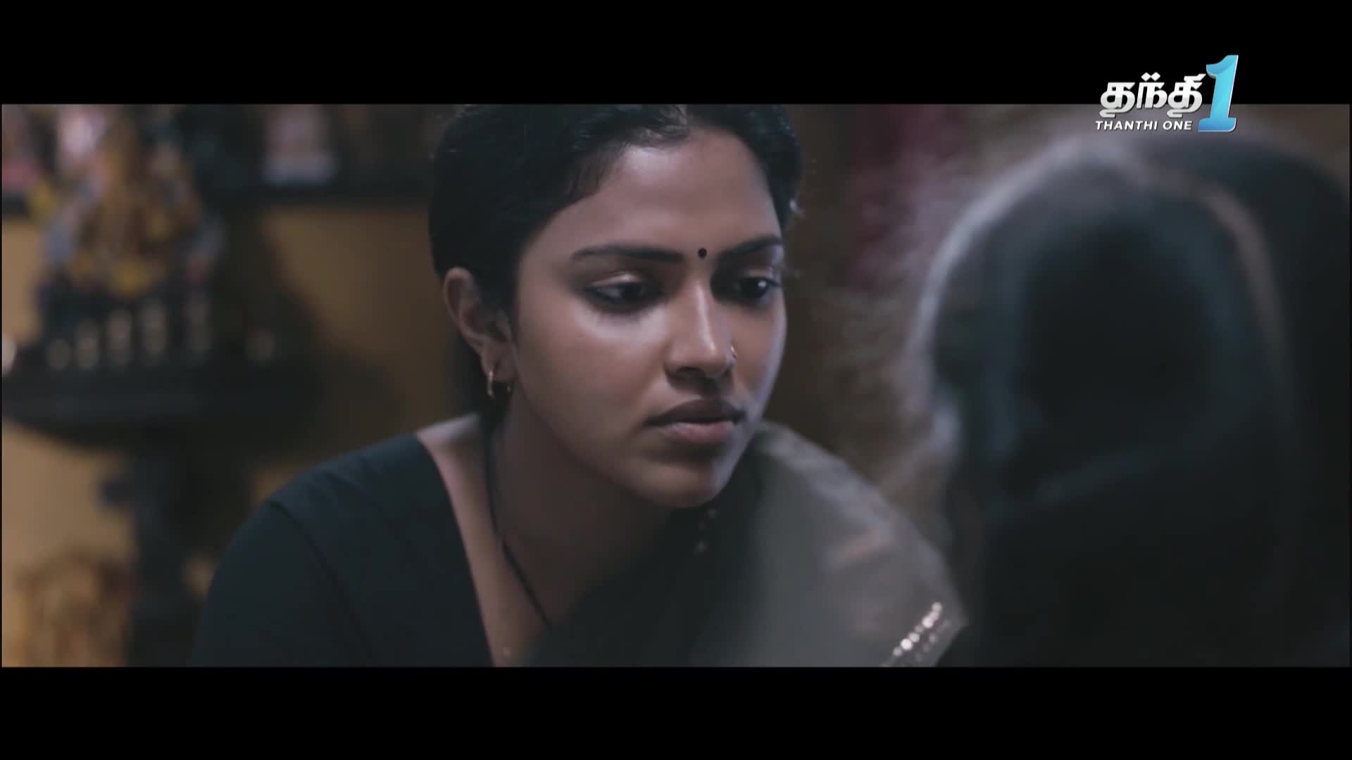 A woman with dark hair and a nose ring looks intently at someone off-screen. The Thanthi One logo is in the corner, suggesting a scene from a show or film in India.
