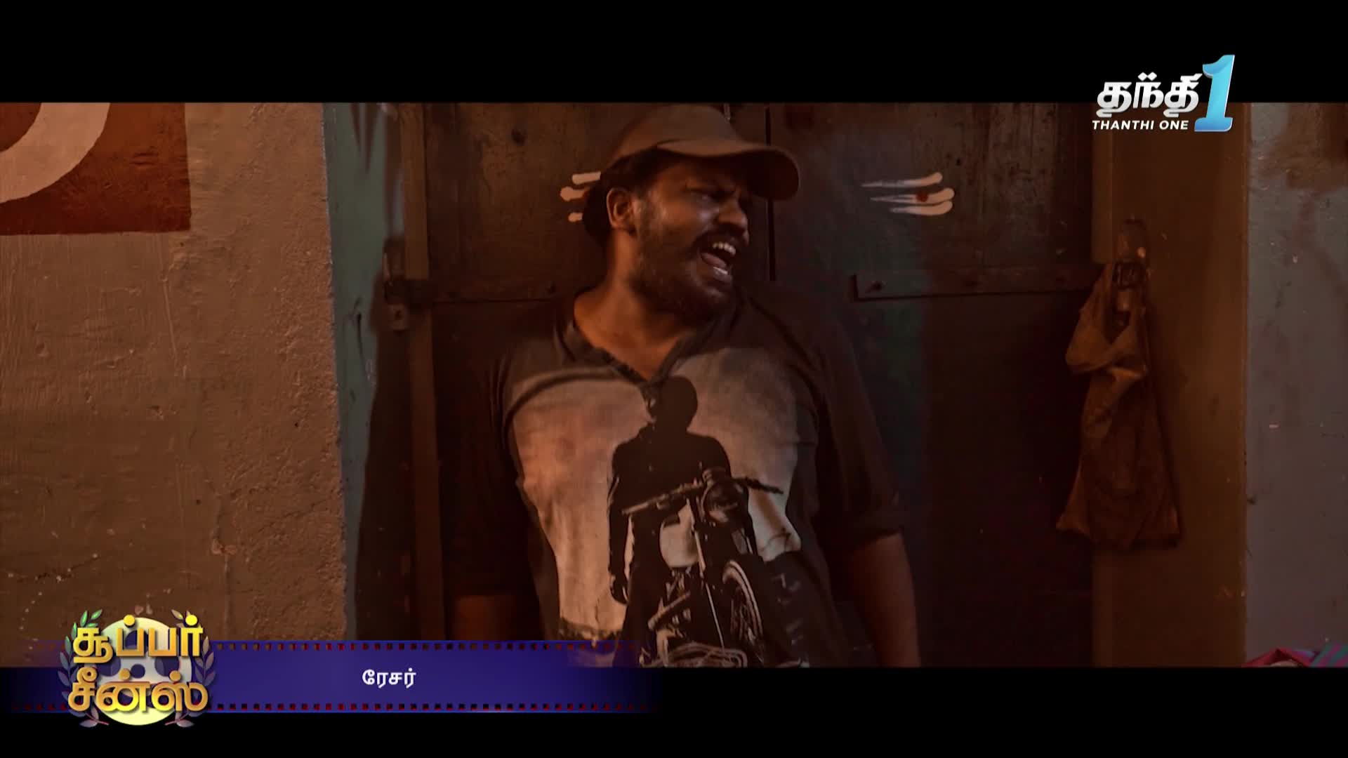 A man wearing a cap and a t-shirt with a motorcycle graphic is leaning against a dark doorway, yelling. The Thanthi One logo is visible in the corner.
