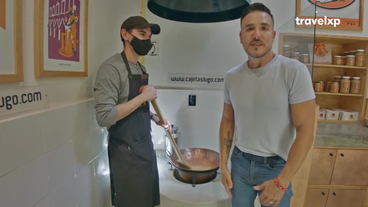 A man in a black apron stirs a copper pot of something creamy with a long wooden spoon. Across from him, another man in a grey t-shirt looks directly at the camera.
A man in a black apron stirs a copper pot of something creamy with a long wooden spoon. Across from him, another man in a grey t-shirt looks directly at the camera.