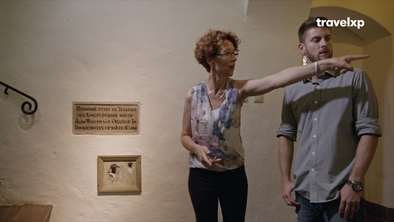 A woman in a floral top gestures towards something unseen as she speaks. The man beside her, wearing a grey shirt, follows her pointing hand.
A woman in a floral top gestures towards something unseen as she speaks. The man beside her, wearing a grey shirt, follows her pointing hand.