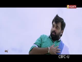 A man in a green striped shirt and a blue and white shawl clutches his chest, looking off to the side. The Vasanth TV logo is in the corner, and the scene is rated CBFC-U.
