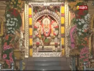 A decorated shrine, framed by floral arrangements, is centered in the shot. The Vasanth TV logo is visible in the top right corner.
