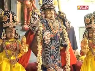 Ornate statues, adorned with elaborate headwear and garlands, stand in a row. The Vasanth TV logo in the corner signals a broadcast from India.
