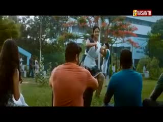 A woman in a white and black outfit is moving quickly, her arms up, as if she's dancing. The logo for Vasanth TV is in the corner, and the scene seems to be set outdoors in India.
