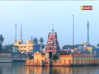 A colorful temple complex, reflected in the still water, dominates the scene. The Vasanth TV logo sits in the upper right corner, indicating a broadcast from India.
