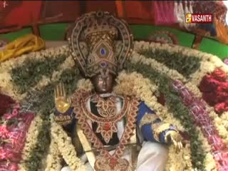 A statue of a deity, adorned with garlands, sits center stage. The Vasanth TV logo is visible in the corner.
