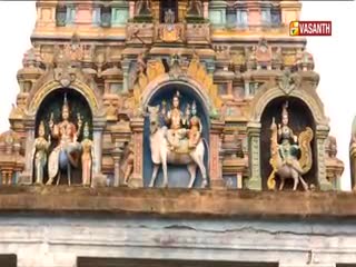 Above, ornate stone carvings of deities and figures adorn the temple's facade. The Vasanth TV logo sits in the upper right corner, suggesting a broadcast from India.
