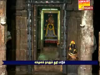 A temple interior is framed by dark stone columns, with a brightly lit shrine visible at the end of a passage. The Vasanth TV logo is in the upper right corner, and a Tamil caption runs across the bottom.
