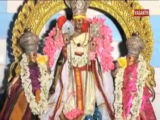 Three figures, adorned with garlands and elaborate headdresses, stand centered within a golden arch. The Vasanth TV logo is visible in the corner, indicating a broadcast from India.
