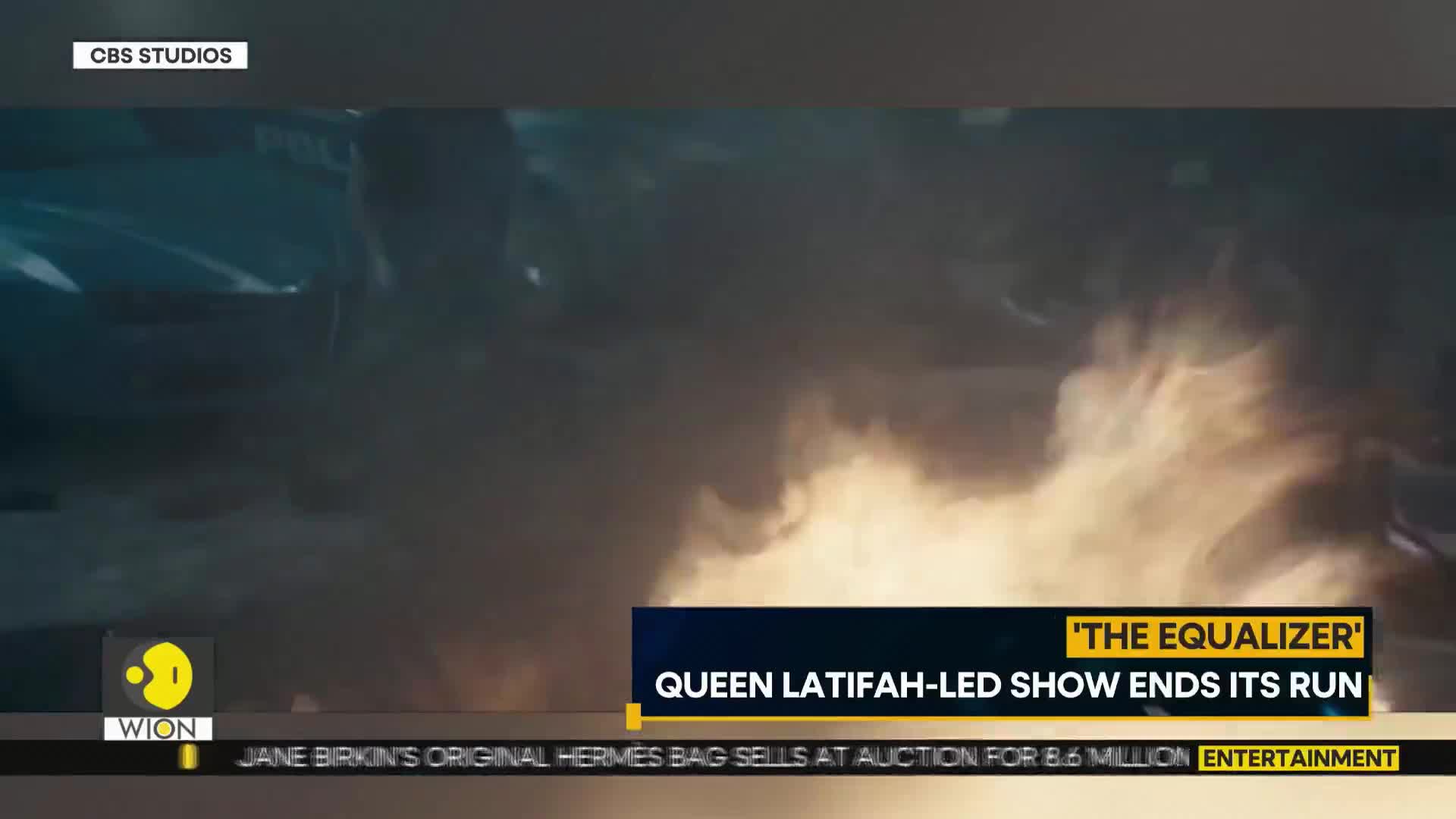 A large fire rages in the foreground, obscuring the scene with smoke. The WION logo appears in the corner, and a headline mentions "The Equalizer" on a CBS Studios broadcast.
