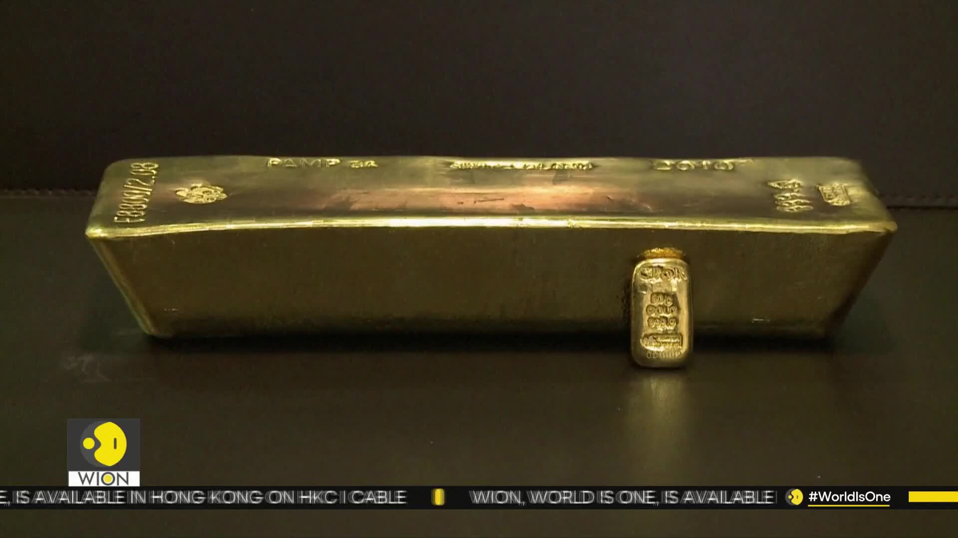 A large gold bar sits next to a smaller one, both gleaming under the studio lights. The WION logo is visible in the corner, suggesting this is a news segment from India.
