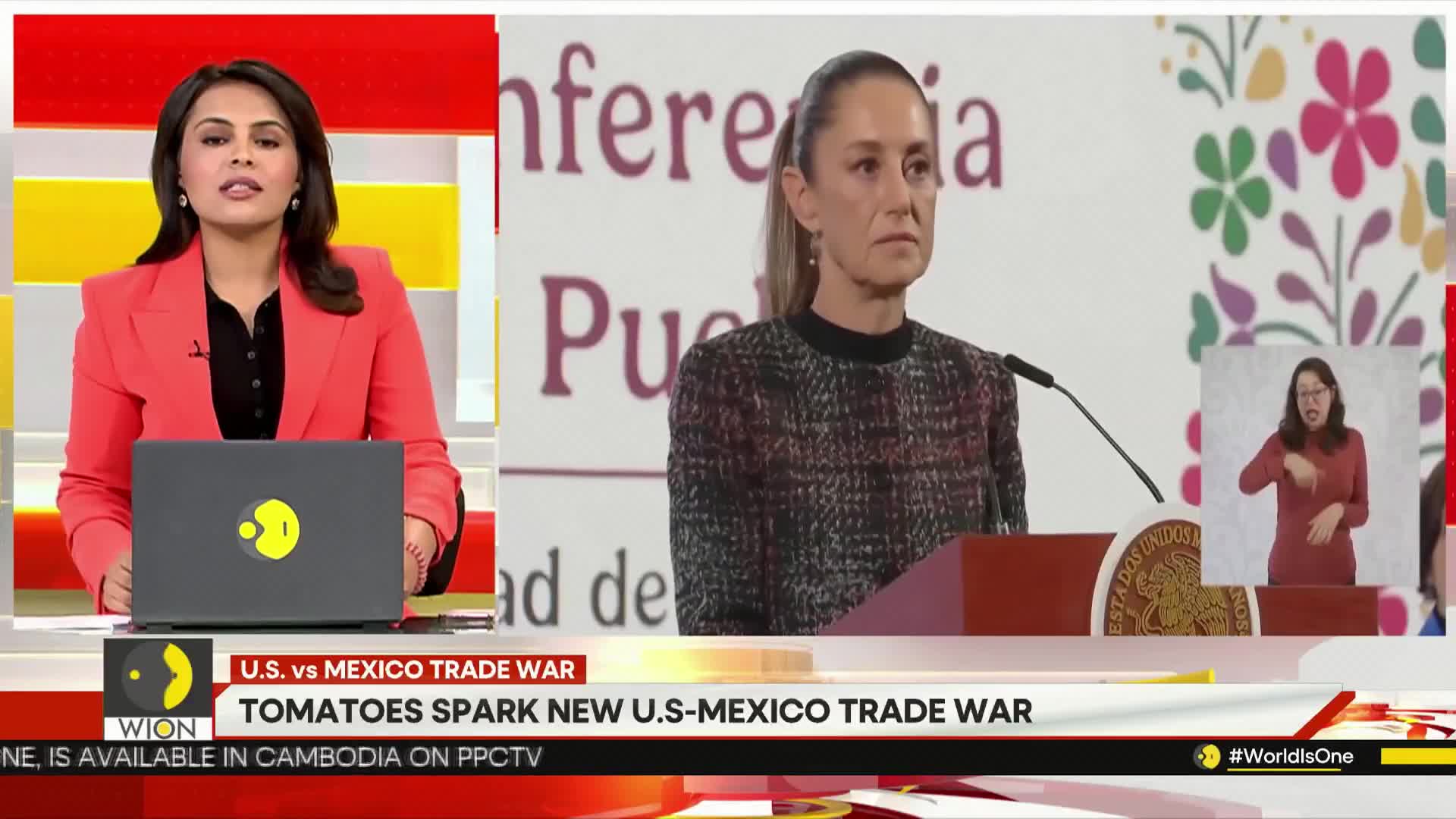 A news anchor in a red jacket is speaking from a studio, while a woman in a patterned sweater stands at a podium. A sign language interpreter is visible in the corner, and the screen shows a headline about a trade war.
