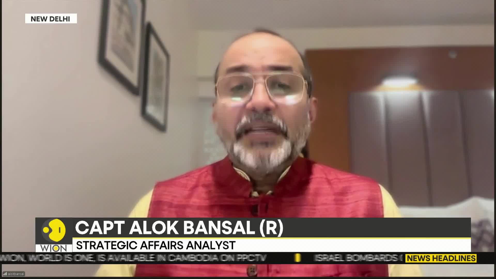 A man in a red vest and glasses, identified as Capt. Alok Bansal, speaks directly into the camera, likely for a WION news segment from New Delhi. The lower third of the screen displays his name and title, along with a news ticker.
