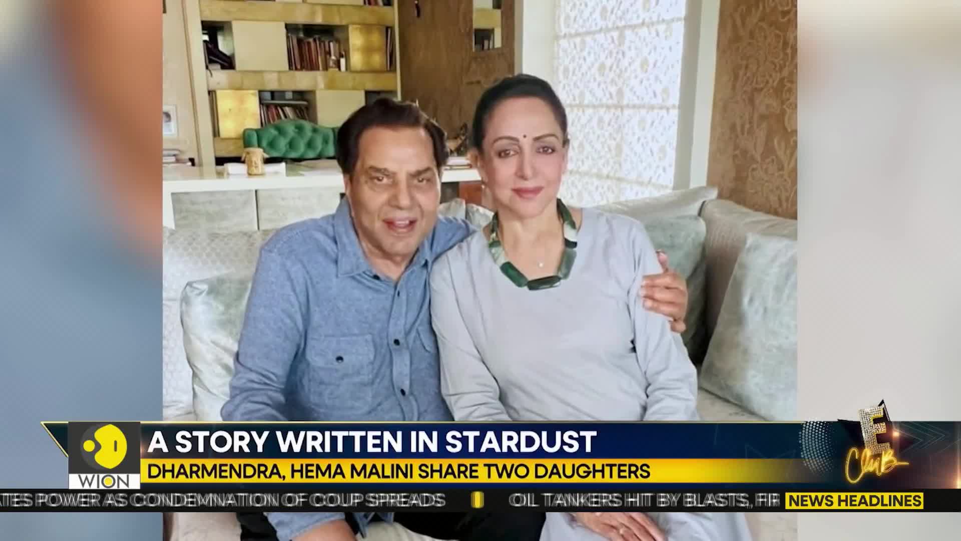 Dharmendra and Hema Malini are seated together, smiling for the camera. The WION news graphic at the bottom identifies them and the story being reported.
