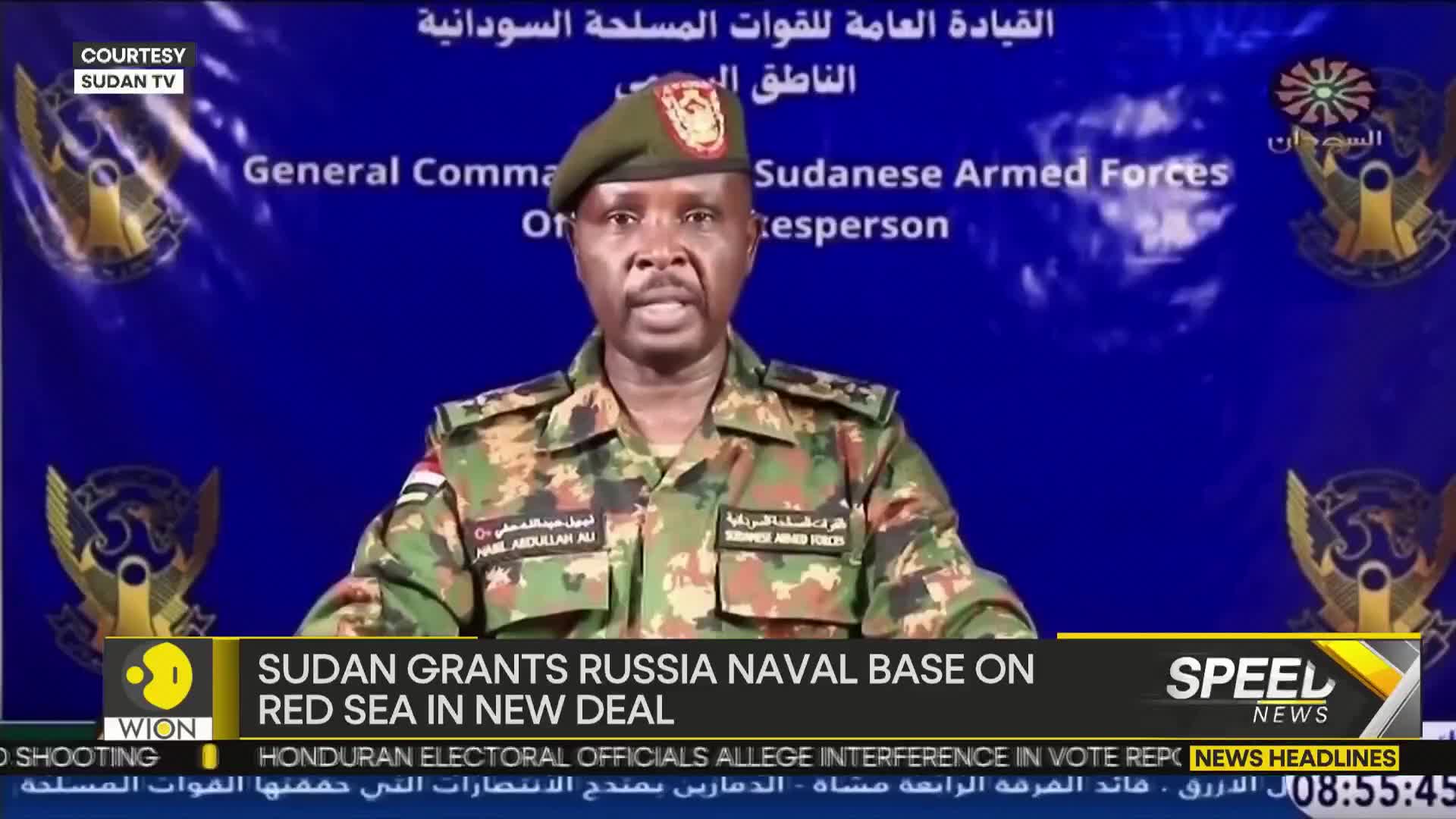 A man in a military uniform speaks directly into the camera, his words likely broadcast by WION. Behind him, a blue banner displays text in Arabic and English, with the words "Sudanese Armed Forces" visible.
