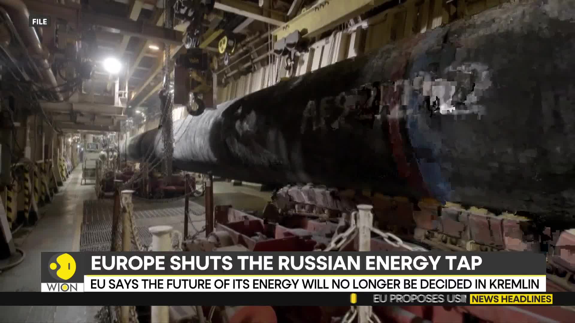 A massive, dark pipe is suspended by a crane inside a large industrial space. The headline from WION, "Europe Shuts the Russian Energy Tap," is displayed at the bottom of the screen.
